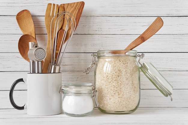 Kitchen tools and glass jar with rice