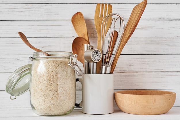 Photo kitchen tools and glass jar with rice