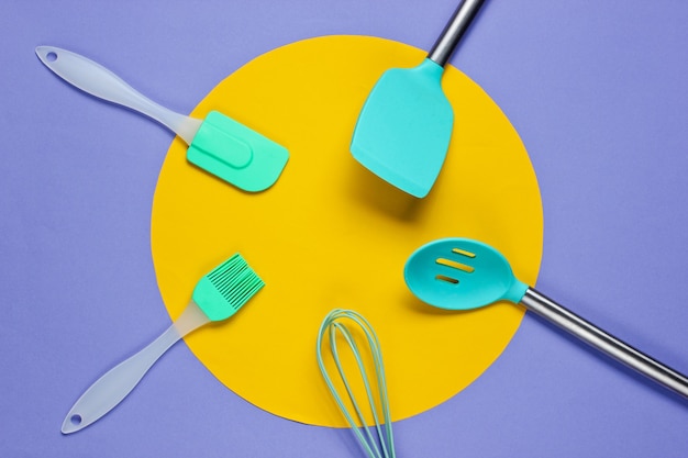 Kitchen tools on purple with a yellow circle in the middle