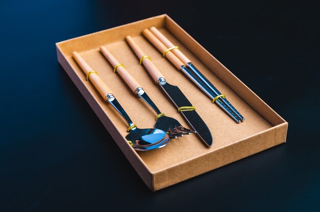 Kitchen tools set with knife, fork, and spoon on dark background