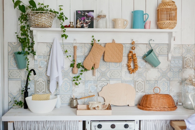 キッチンタオルとモダンなキッチンのワークトップの手袋、白い壁のルーフレールにぶら下がっているキッチンアクセサリー