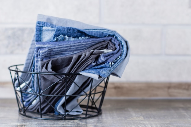 Kitchen towels and napkins in metal backet on a table