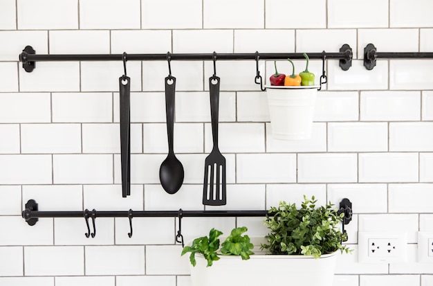 Photo kitchen utensil hanger on white brick wall