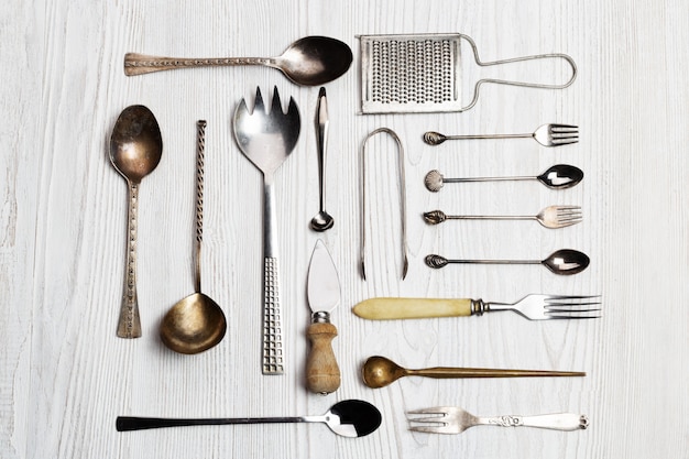 Sfondo di utensili da cucina - cucchiai, forchette, coltello da formaggio, grattugia, tenaglie