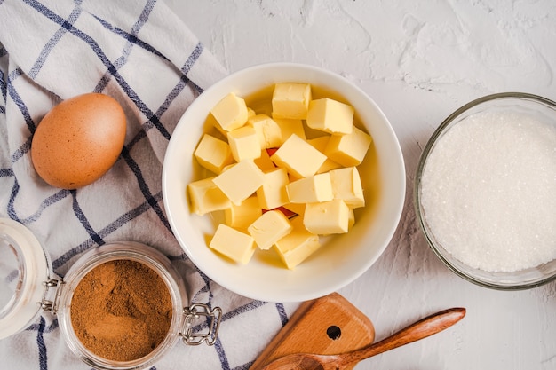 Kitchen utensils and baking ingredients for cupcakes on white stone background