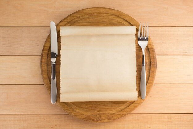 Kitchen utensils at cutting board on wooden background