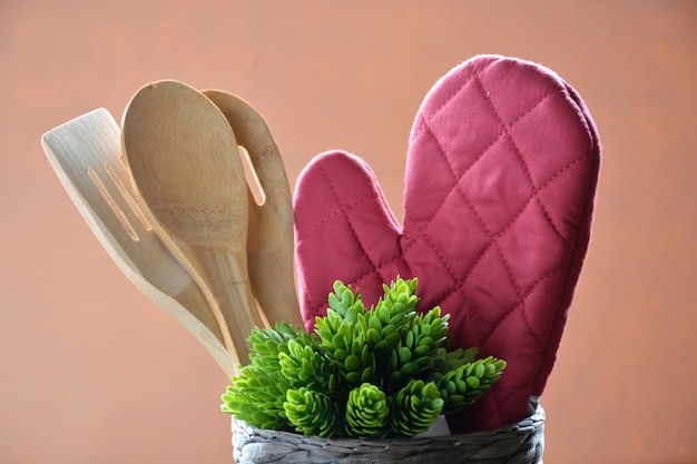 Kitchen utensils such as oven gloves, spoons in wood and slate to write down the menu