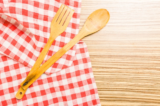 Kitchen utensils on tablecloth on wooden table over