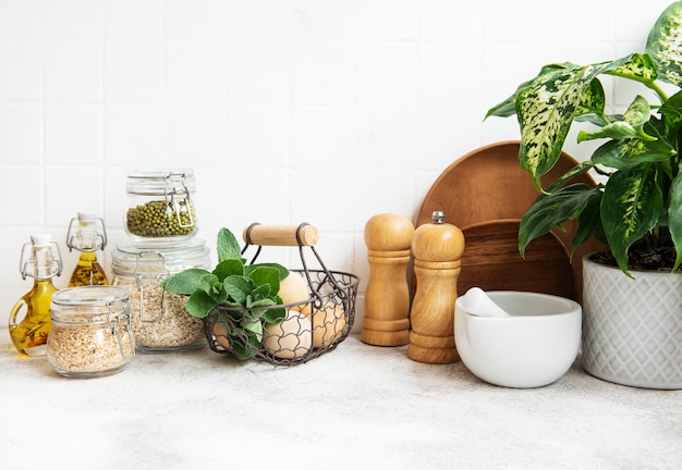 Kitchen utensils, tools and dishware on on the background white tile wall. Interior, modern kitchen space in bright colors. Blank space for a text, front view