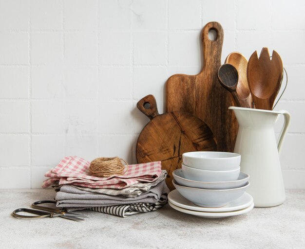 Kitchen utensils, tools and dishware on on the background white tile wall. Interior, modern kitchen space in bright colors. Blank space for a text, front view