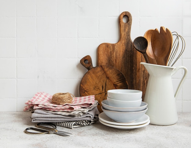 背景の白いタイルの壁に台所用品のツールと食器