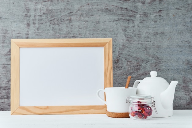 Kitchen utensils with empty white paper, teapot, cup and a honey in glass jar