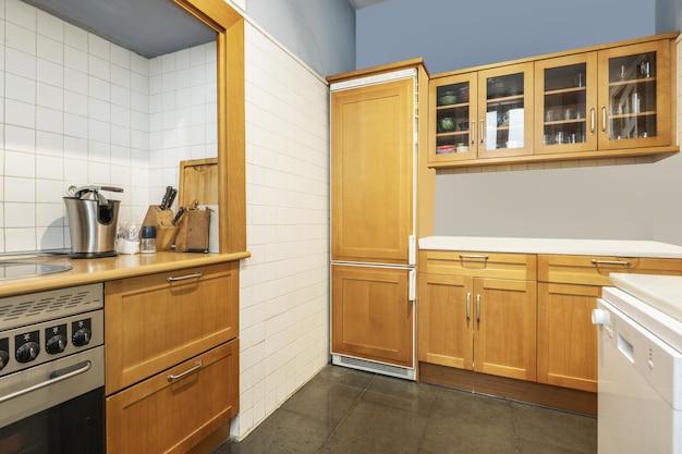 Kitchen with amber cherry wood cabinets wood countertops and builtin appliances white tiles