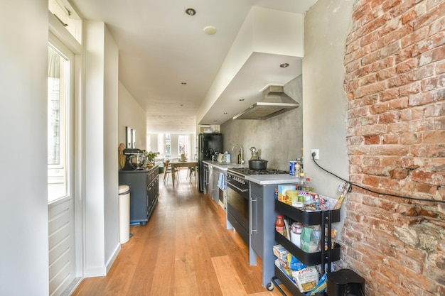 A kitchen with an exposed brick wall and gray counter