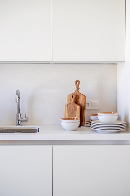 A kitchen with a sink and a cutting board on the counter.