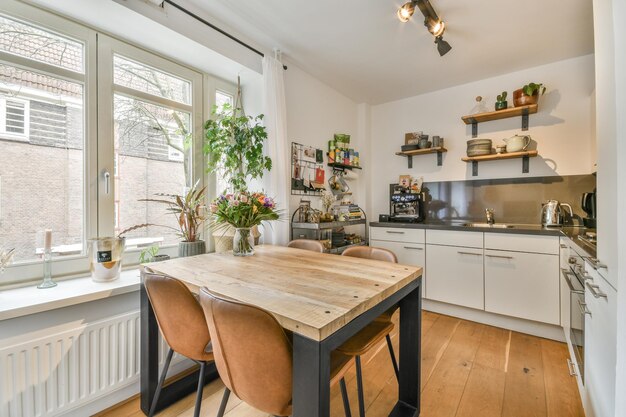 Photo a kitchen with a table and chairs and a window