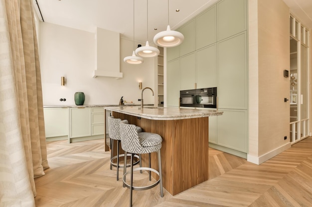 A kitchen with white cabinets and a marble counter top