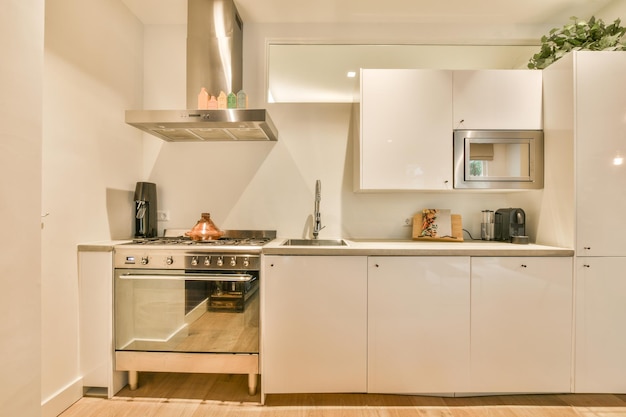 A kitchen with white cabinets and a stove and sink