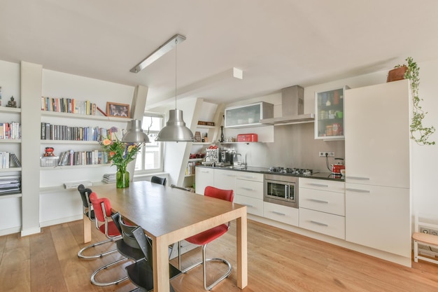 A kitchen with white cabinets and a table and chairs