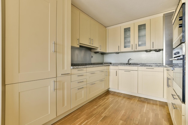 A kitchen with white cabinets and a wood floor