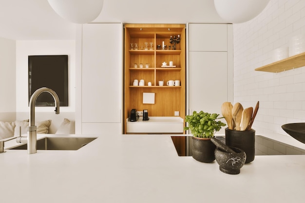 Photo a kitchen with white counters and wooden shelvings in the center of the photo is an open cabinet