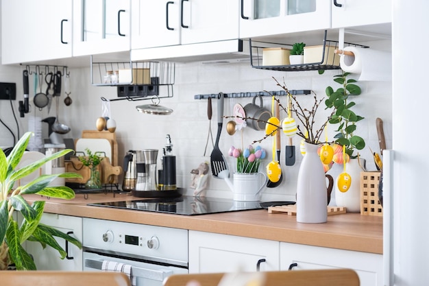 A kitchen with a white kitchen counter and a shelf with kitchen utensils hanging from the ceiling.