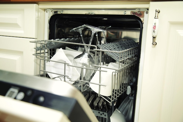 Kitchen Woman with a clean wine glass on background dishwasher