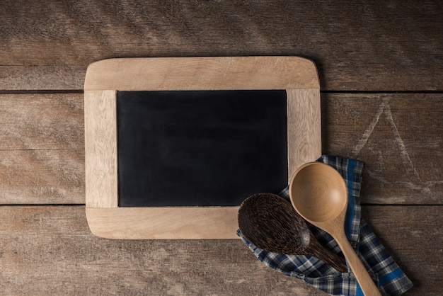 Kitchenware on a blackboard with a blue checkered napkin