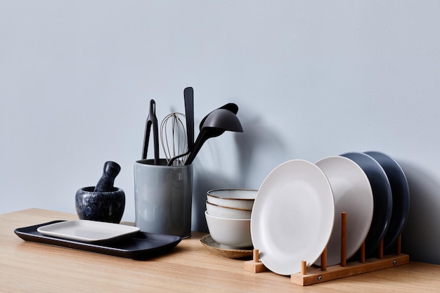 Кухонные принадлежности для приготовления пищи в стекле с керамической посудой на кухонном столе