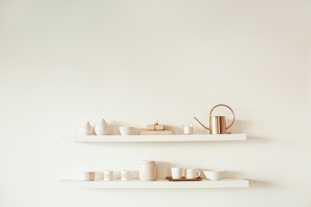 Kitchenware utensils on shelf on white surface