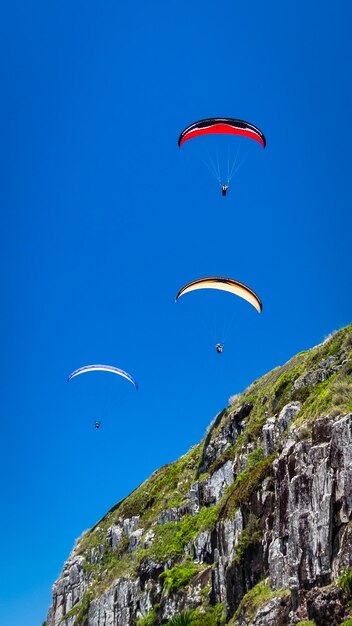 Foto un aquilone che vola sopra la montagna contro il cielo blu