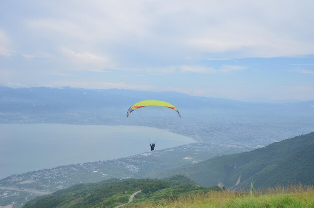 Kite flying over mountain against sky