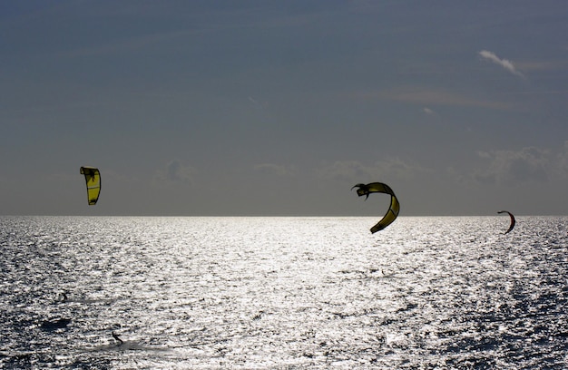 Foto kiteboarding in mare contro il cielo in una giornata di sole