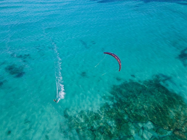 Kitesurfer op turquoise kristalhelder water vanuit de lucht