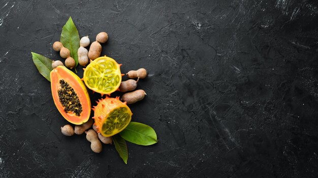 Kiwano and papaya on a wooden board Top view Free space for text