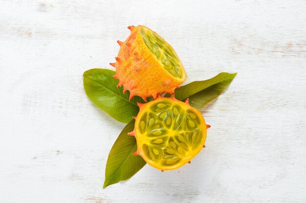 Kiwano on a white wooden background. Tropical Fruits. Top view. Free space for text.