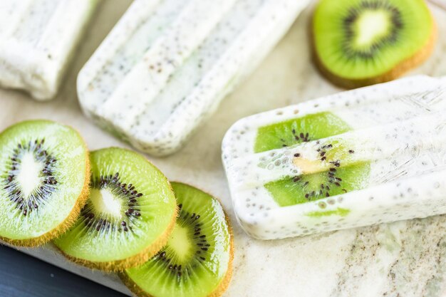 Kiwi coconut chia popsicles on granite board.