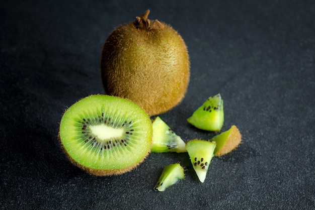 Kiwi fruit on black stone low key light