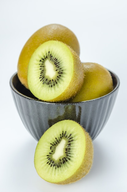 Kiwi fruit and half with black bowl 