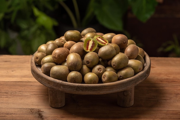 The kiwi fruit on the plate is on the wooden table