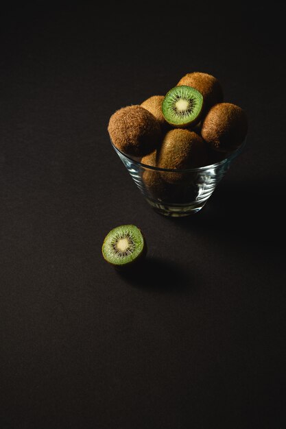 Kiwi fruits half sliced in glass bowl, angle view