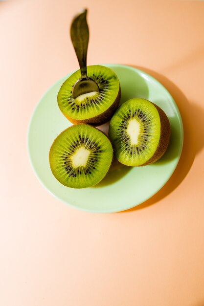 Kiwi fruits isolated on plate with dessert spoon. Cut of green sweet kiwi. Detox, weight loss, eating vegetarian. healthy diet . 