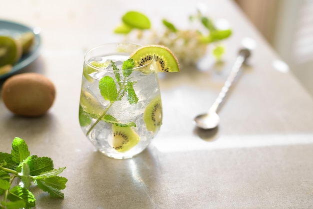 Kiwi mojito cocktail or caipirinha drink recipes with mint and ice in glasses close up summer cold