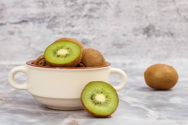 Kiwi's in porseleinen kom op de stenen tafel