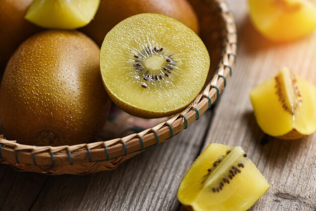 Kiwi slice on basket, close-up of yellow kiwi fruit on wooden table