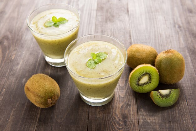 Kiwi smoothie with fresh fruits on wooden table