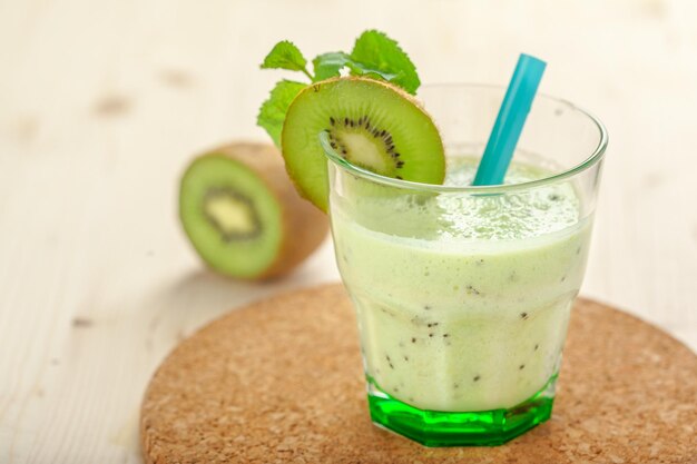 Kiwi smoothies in glass on wooden table