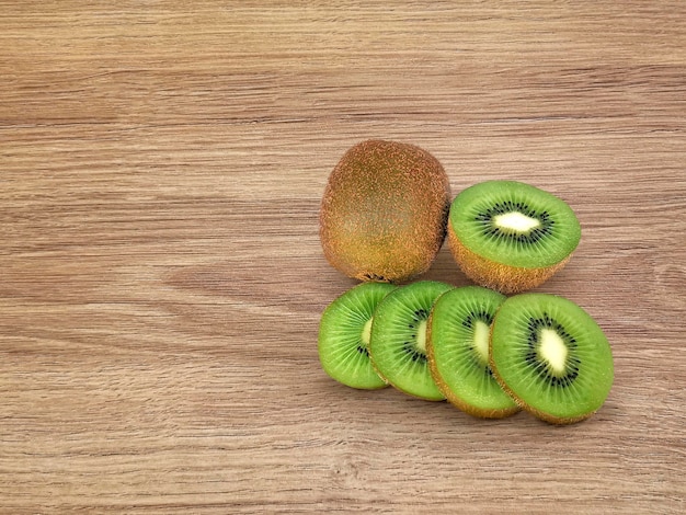 Kiwi splits kiwi pieces on a wooden floor with space for text