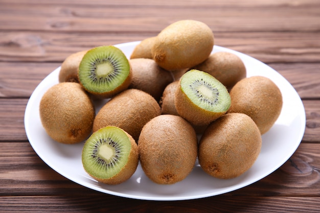 Kiwi in white plate on brown background