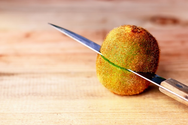 Kiwifruit die op houten vloer snijdt